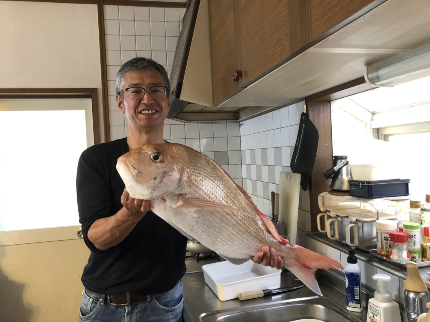 室内で釣ったマダイを手にする松本さん
